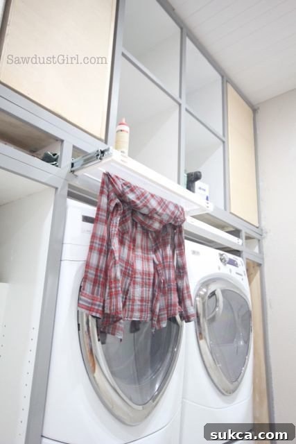 Laundry Room Cabinet Doors Project Update Custom cabinet doors in a modern laundry room design, featuring a convenient hanging rack for drying clothes.