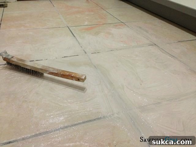 Aggressively scrubbing paint and stripper residue from tile and grout with a steel brush