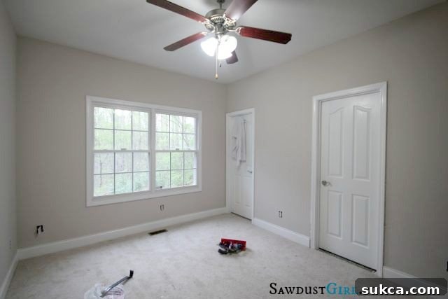 Empty room with large window, showing natural light and potential layout for a home office.