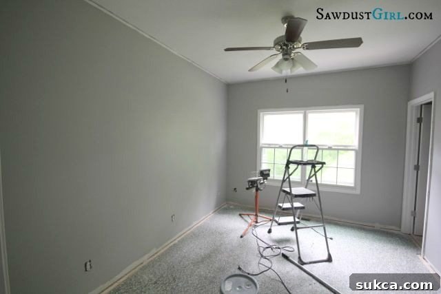 Before: Office space with existing lights and wall texture before renovation. The room is getting ready for a major DIY transformation.