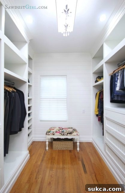 Master closet featuring plank wall and white cabinetry for organized storage Spacious master closet showcasing the new plank wall and ample white storage