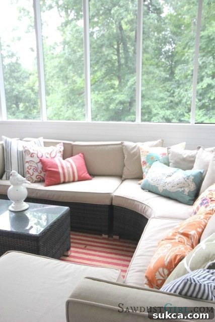 Beautifully decorated screened-in porch, featuring comfortable seating and a cozy atmosphere for outdoor relaxation in a DIY home.
