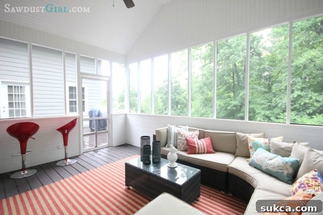 Wide view of a comfortable screened-in porch with seating area and natural light, showcasing a relaxing outdoor living space.