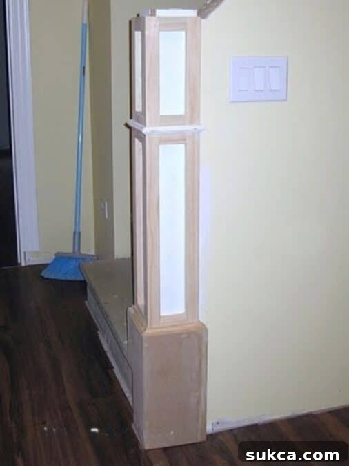 In-progress DIY newel post showing 1x2 trim detail and raw MDF construction