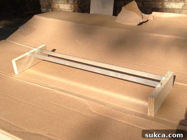 Metal hanging file bars positioned in scrap wood for easy spray painting.