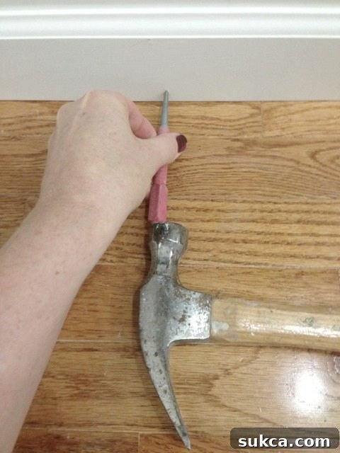 Using a towel to protect the surface while sinking a nail with a nail set