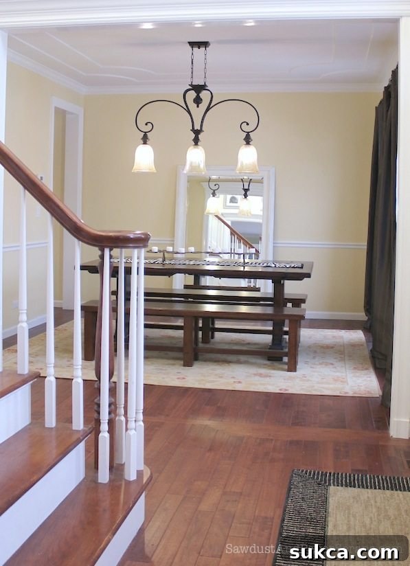 Elegantly designed formal dining room with modern chandelier and classic furniture.