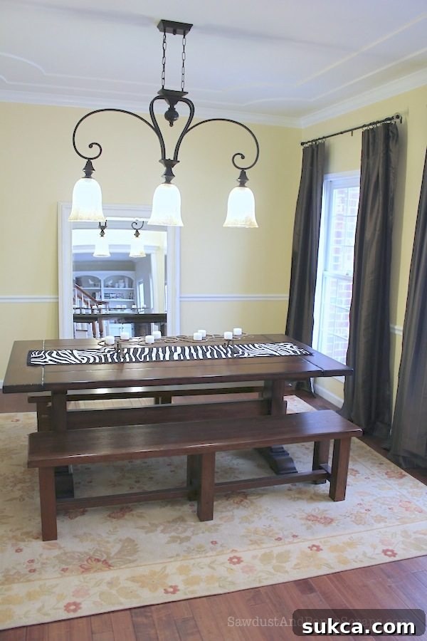 Transformed dining room with new paint, lighting, and flooring, showcasing a modern elegant design.