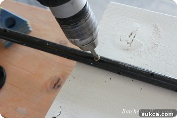 A metal stake attached to the back of a DIY tombstone with screws, ready for ground installation.