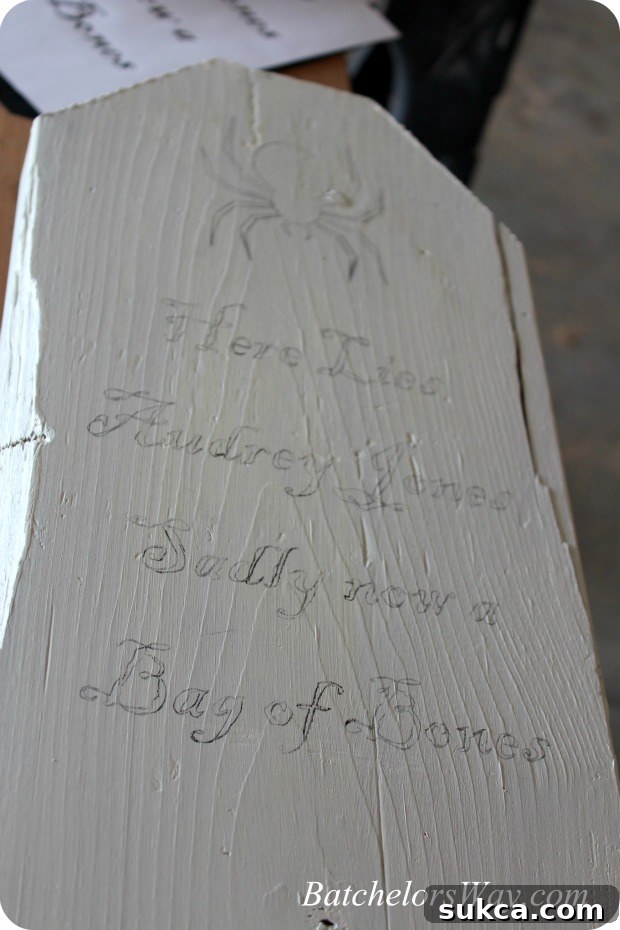 A DIY tombstone with a traced outline of a spooky design and epitaph, ready for painting.