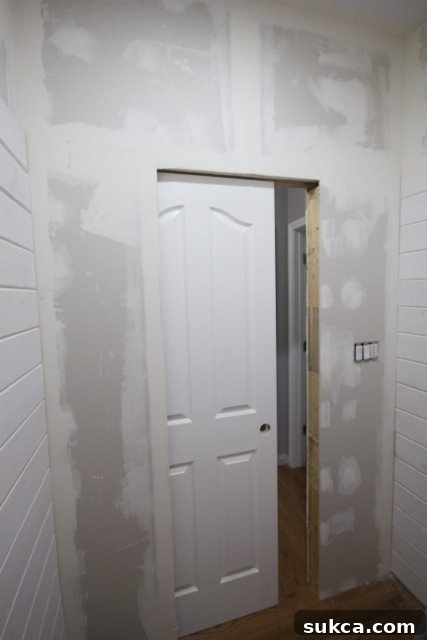 Powder room walls with planks, awaiting door casing before final wall treatment.
