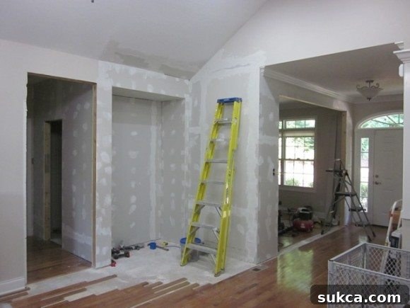 Newly installed drywall and mudded seams in the living room, ready for finishing.