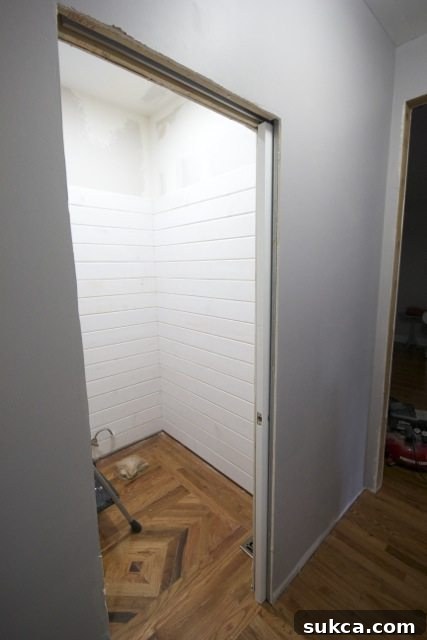 Progress shot of a powder room featuring unique wood floor design.