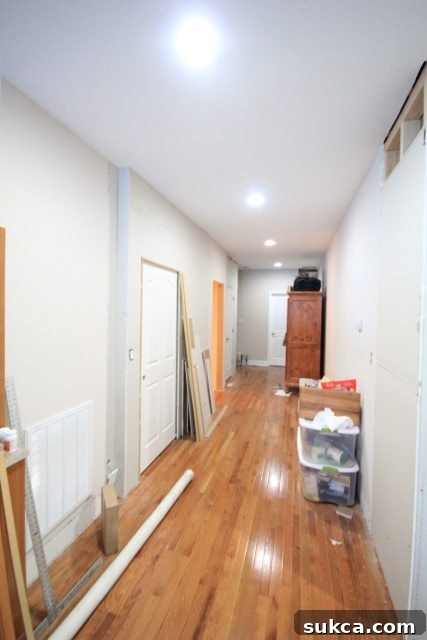 Wide hallway leading to master bedroom with a new space-saving pocket door installed for the laundry room.
