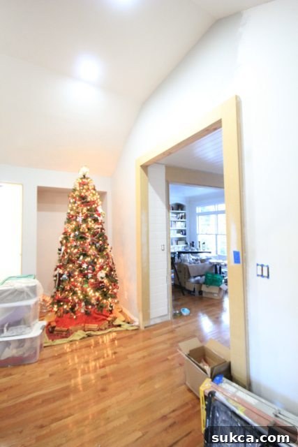 Christmas tree set up in a partially renovated home, adding festive cheer amidst ongoing construction.