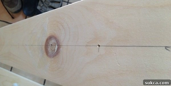 Marking Drill Points for Shoe Pegs Close-up view of a wooden board with marked lines and hash marks indicating where to drill holes for the DIY shoe organization pegs.