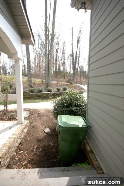 The new side entrance with surrounding landscape, highlighting the large green bush used for concealment.