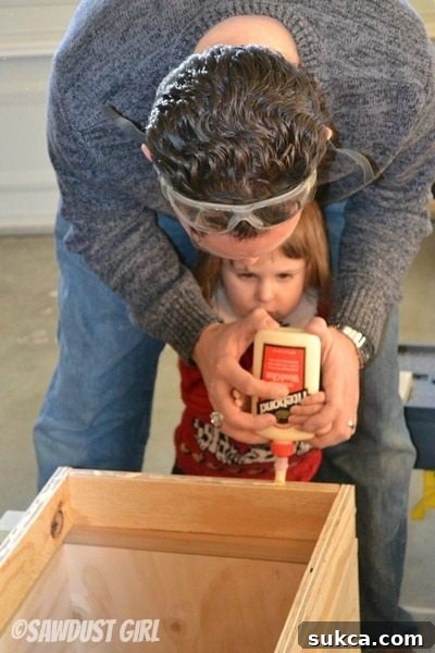 Children writing names with wood glue on custom window seat