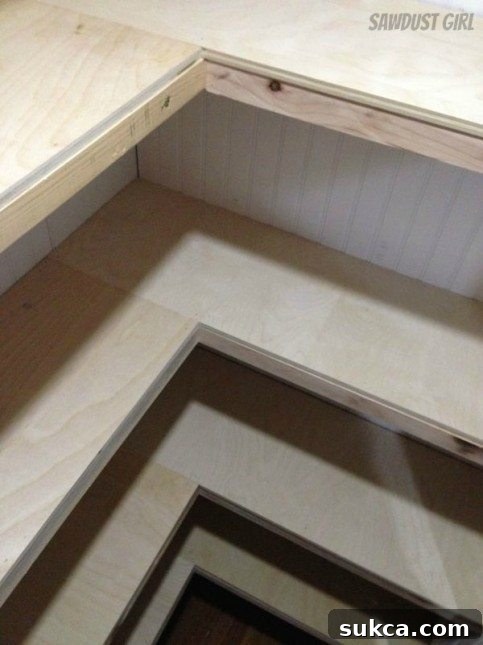 In-progress view of U-shaped shelf installation in a white-painted hallway closet.