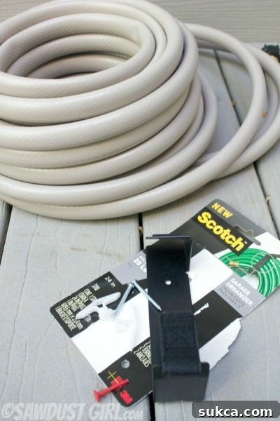 Close-up of the Scotch Garage Organizer installed on a wall, ready to hold a garden hose.