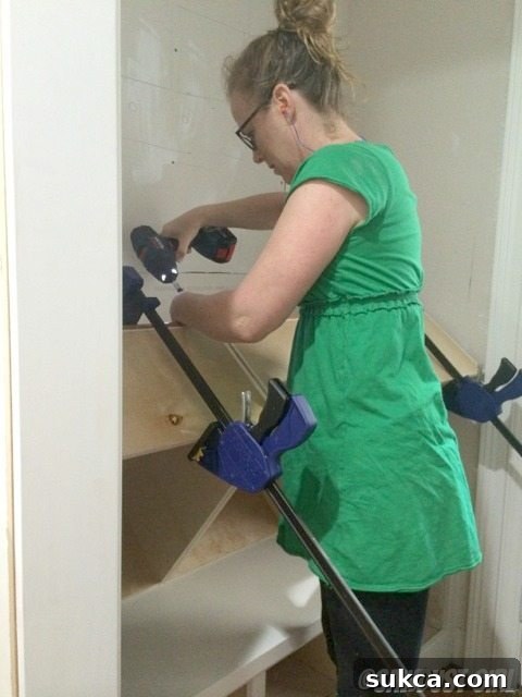 Detailed process of installing a French cleat onto the back of a cabinet.