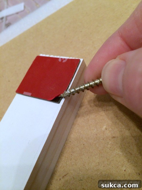 Tip for easily removing adhesive backing with a nail or screw