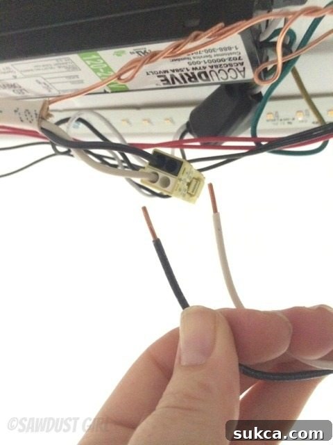 Pushing wires into color-coded quick-connect terminals on LED light