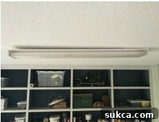 Old light fixture barely hanging from the ceiling