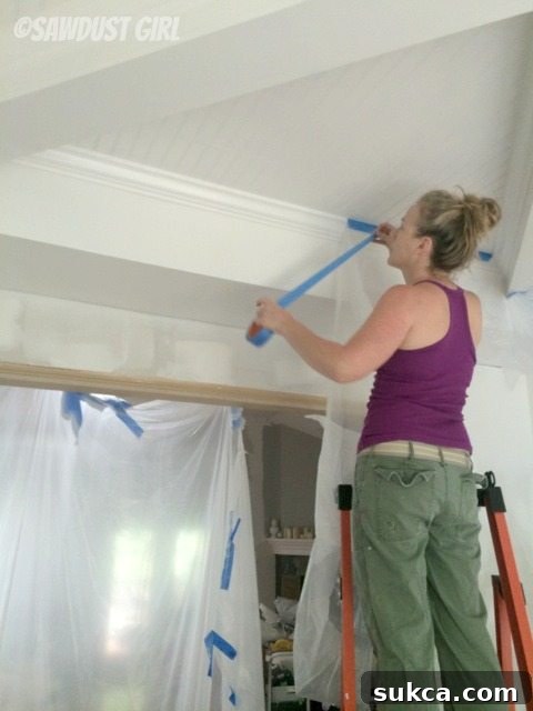 Masking for Two-Tone Ceiling Design The dining room ceiling with white areas meticulously taped off and masked in preparation for the second paint color