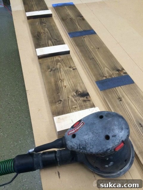 Prepping for Final Assembly Sanding off excess finish from the top of wooden blocks to prepare for final gluing.