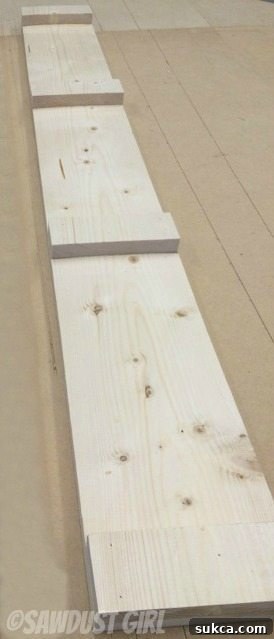 Attaching Spacing Blocks Securing 2-inch wooden blocks to a 44-inch board using glue for a magazine rack frame.