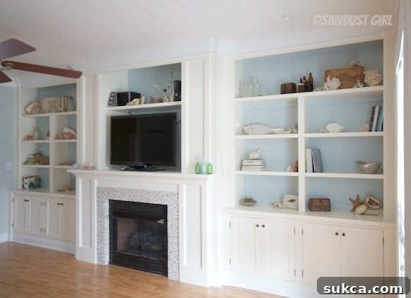 Transformed living room with sleek white built-in cabinetry around the fireplace