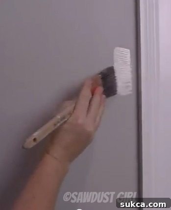 Applying initial paint to the wall, away from the trim, to offload brush