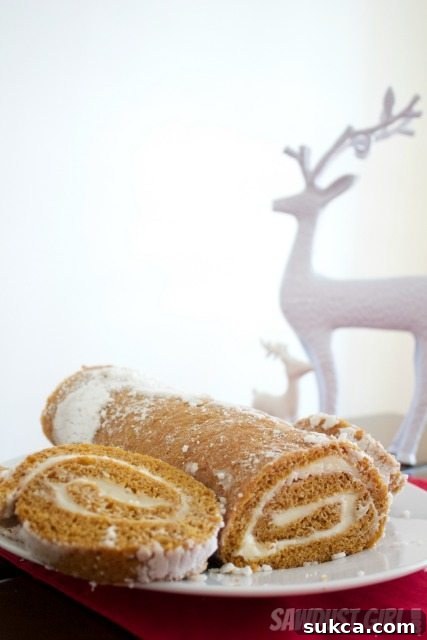 A beautifully crafted homemade pumpkin roll Homemade Pumpkin Roll, perfectly sliced and ready to serve, showcasing the creamy filling