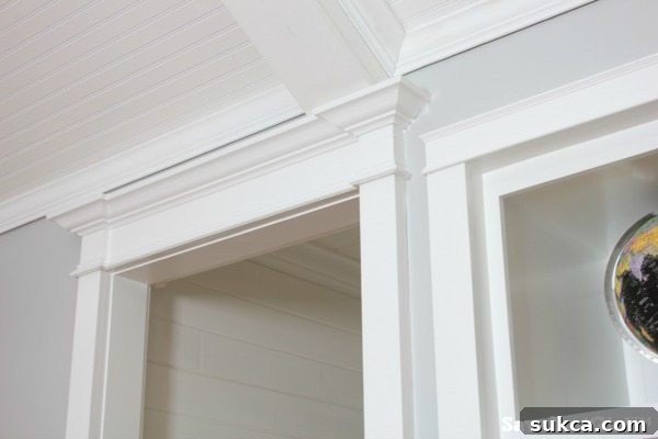 Corner detail of multi-layered crown molding in the hallway, demonstrating stepped-out design and precise craftsmanship.