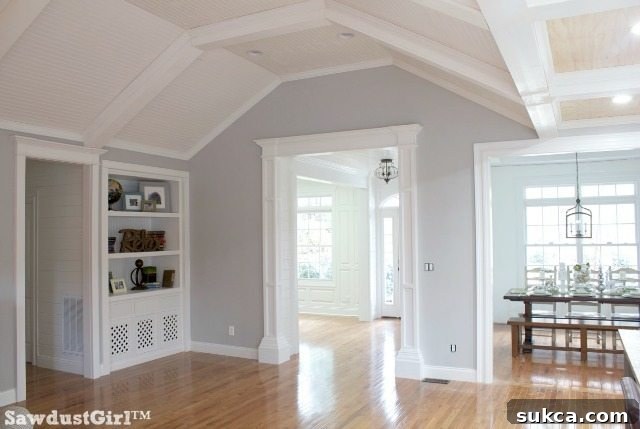 Spacious living room featuring a detailed box-beam ceiling and abundant natural light.