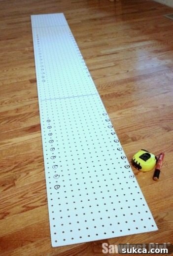 Detail of a DIY shelf drilling jig showing hole spacing and markings