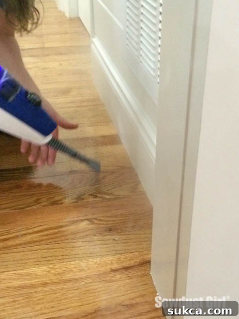 Applying steam directly to a dried paint spot on a wood floor to soften it