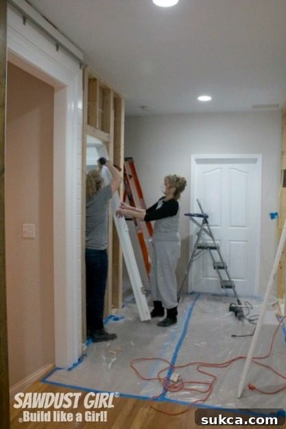 The hall closet, a previously functional space, is now undergoing demolition as part of a larger home renovation project.