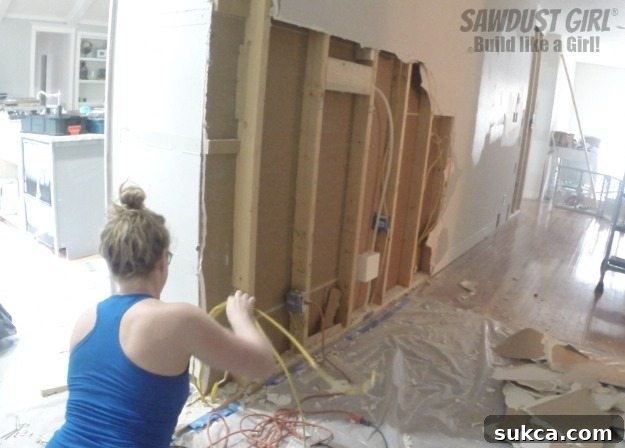 Careful handling of electrical wiring during renovation to ensure safety and proper rerouting, highlighting the meticulous process of getting wiring out of the way for new construction.