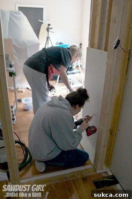 Madison and Penny diligently working to complete the interior drywalling of the new pantry, a testament to our DIY team's effort.
