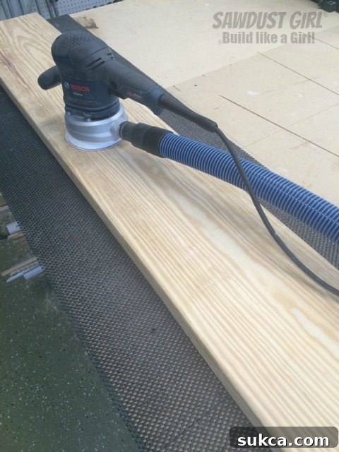 Tool Box Liner in Use for Sanding A wooden board resting on a red textured tool box liner on a wooden workbench, showcasing stability for sanding.