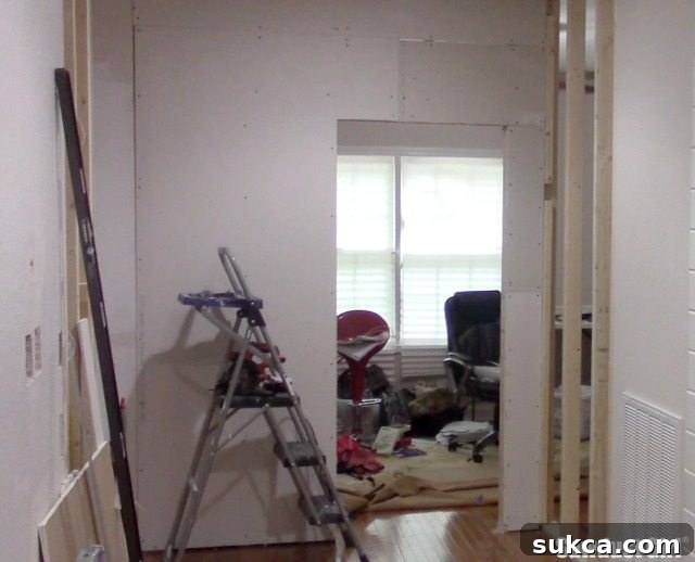 Drywall completion on both sides of the office wall, showing significant progress.