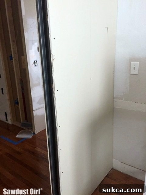 A close-up view of the newly drywalled office wall, awaiting final finishes.