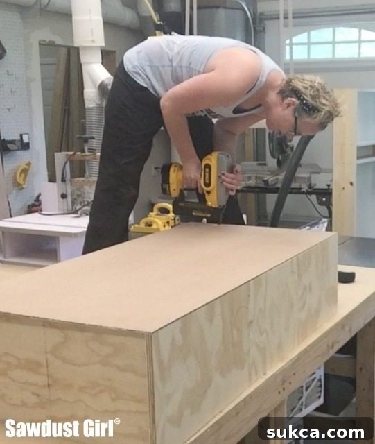 The back panel being attached to the pantry cabinet frame using a nail gun, ensuring structural integrity.