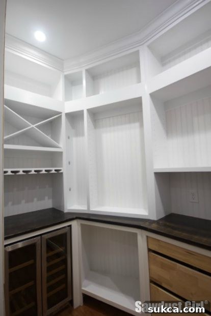Inviting pantry entrance with refined details White kitchen with wood countertops and pantry entrance