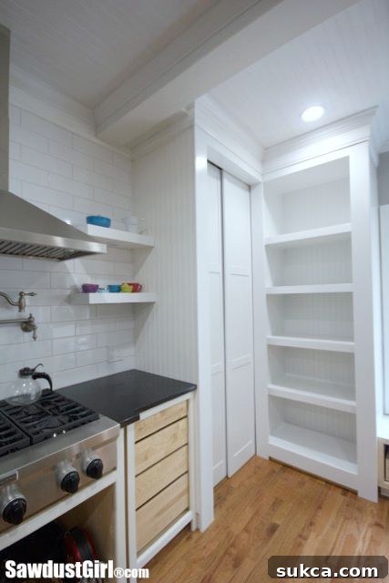 Finished DIY sliding pocket doors for the hidden pantry, shown fully open to reveal the interior space.