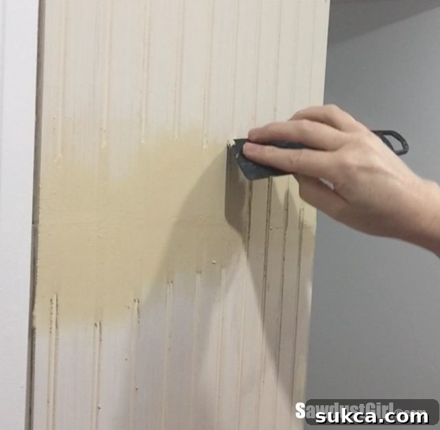 Cleaning excess wood putty from beadboard grooves.