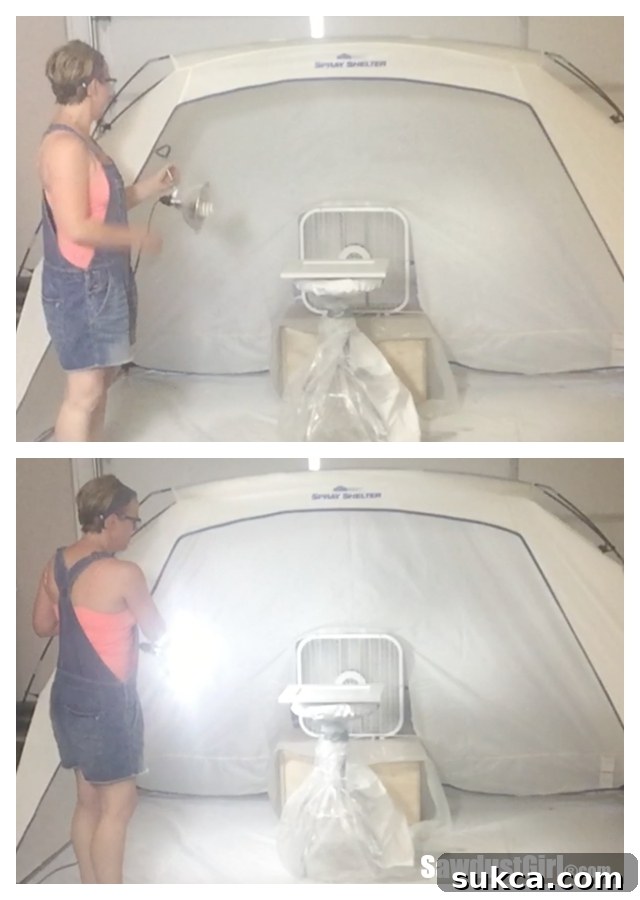 A portable work light clamped to the interior of the spray shelter, providing essential angled illumination for detecting imperfections during painting.