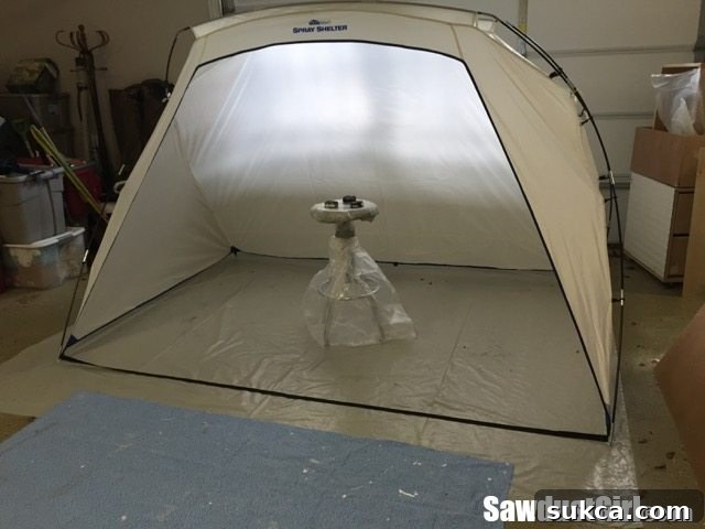 The spray shelter meticulously set up within the garage, creating a dedicated and protected area for painting.